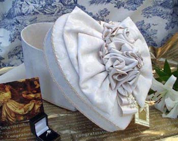 Pandora's Fabric Covered Decorative Hat Boxes are hand made and individually designed using fabrics such as moire, silk, damask, fake fur and tartan. These boxes are ideal as gifts for all occasions, including birthdays and weddings. Store your hats inside, as well as accessories, jewellery and mementos. These are decorative and useful fabric covered boxes available in various shapes: heart, round, rectangular, square, oval, hexagonal.